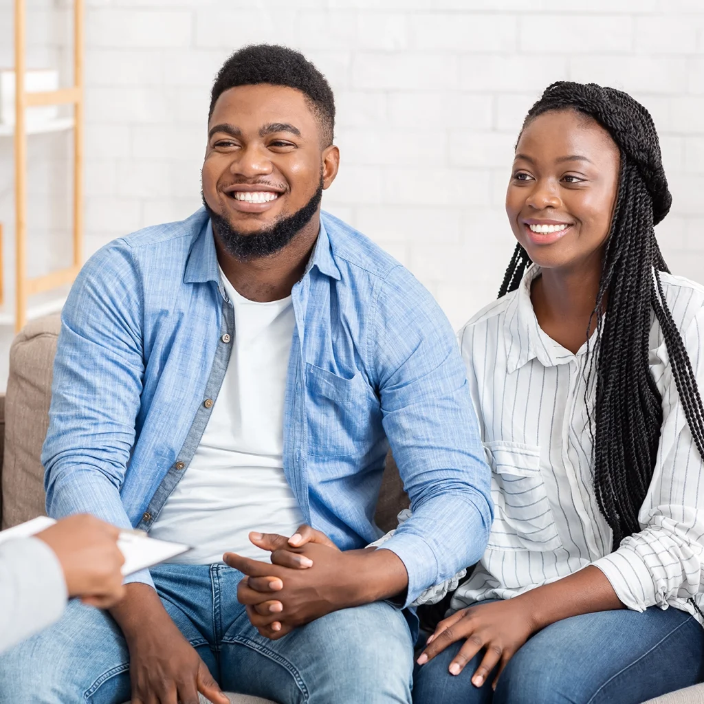 A black couple sitting holding hands